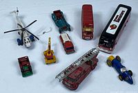Group shot of all nine die-cast vehicles and helicopter