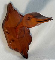 Front perspective of carved bird head and plaque