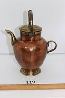 Front view of hammered copper kettle with brass handle, spout, lid and base