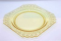 Full view of pale yellow octagonal plate showing scalloped edges and etched floral border