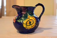 Side view of pitcher showing floral design and handle