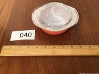 Casserole with lid beside ruler showing scale