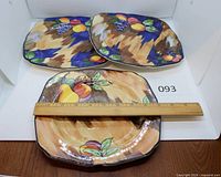Three hand-painted plates with ruler showing 9-inch width