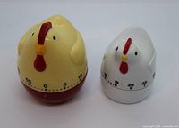 Front view of both chicken timers showing dials and coloration