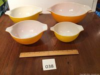 Front view of all four nested bowls with ruler for scale