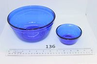Large and small cobalt glass bowls beside ruler