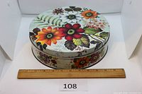 top view showing floral lid design and ruler for scale