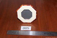 Front view showing octagonal shape, tortoiseshell edge, ivory face, black mat