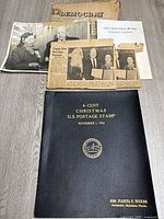 Overview of folder front cover and three newspaper clippings