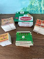 Overall view of five stacks of Atlas labels and Clicquot Club carrier