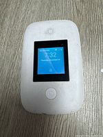 Front view of white Cloud Mobile hotspot showing touchscreen display with time and date