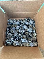 Open cardboard box filled with hundreds of Mr. Pibb branded bottle caps