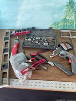 Group shot showing level, socket sets, cordless driver, yardstick, garden cultivator and other tools