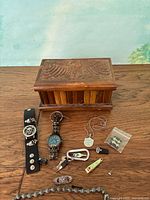 Lot overview showing carved wooden box and assorted jewelry pieces