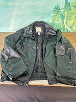 Full view of black leather Covington jacket opened to show lining and collar tag