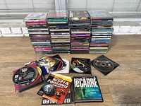 Wide view of two tall stacks of jewel-case CDs and several loose discs, showing variety