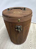 Front view of wooden barrel humidor showing clasp and leather band