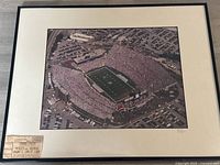 Full view of framed photograph with ticket stub