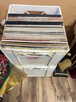 stacked white plastic record crates filled with vinyl LPs