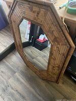 Full view of bamboo octagonal mirror standing on floor