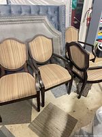 Four matching wood dining chairs with striped upholstery