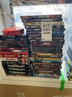 Two tall stacks of DVDs on windowsill showing majority of lot