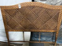 Front view of wicker rattan headboard showing full weave pattern and wood legs