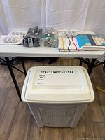 Laundry hamper, showerhead package, curtain package and hooks on table