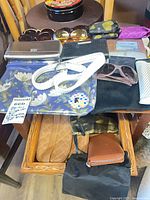 Top view showing sunglasses, wallets, belt, makeup bags, grocery bag pouches