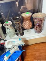 Four patterned glass vessels on windowsill