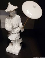 Front view of entire porcelain figurine with parasol