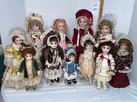 Front view of all eleven dolls on stands