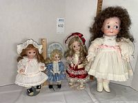 Front view of all four dolls on stands