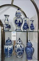 Full view of all seven blue and white porcelain pieces on shelves