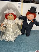 Bride and groom Cabbage Patch dolls front view with measuring tape for scale