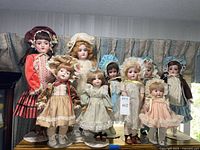 Group shot of nine porcelain dolls on stands