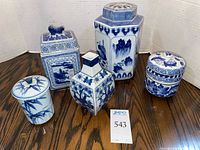 Front view of all five blue and white porcelain lidded pieces