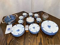 All items grouped: porcelain plates, cups, stainless pot, tealight holder