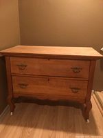 Front view of wooden dresser showing two drawers and brass pulls