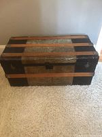 Closed trunk front/top view showing metal cladding and wood slats