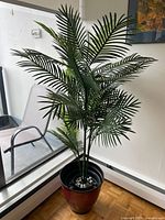Full view of artificial palm in ombré planter by window