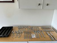 Full lot laid out: knives, forks, spoons, tray