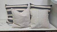 Front view of four striped cushions on marble surface