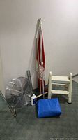 All items grouped: fan, pole with flag, level, stool, tarp, paint thinner bottle visible
