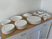 Full set on countertop showing stacks of plates, serving pieces, cups