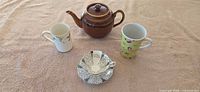 Group shot showing teapot, two mugs, teacup and saucer