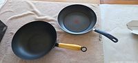 Top view of wok and frying pan showing interiors and handles