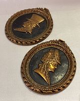 Both oval brass plaques showing male and female profiles