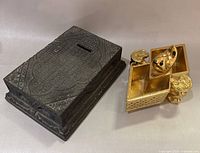 Cast metal bank and gilt inkwell side by side