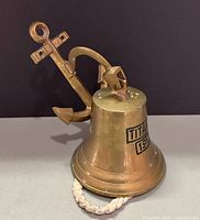 Front view of brass bell with TITANIC 1912 inscription and anchor mount